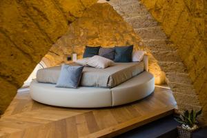 een bed in een kamer met een stenen muur bij A casa di Mammì nella Valle dei templi in Agrigento