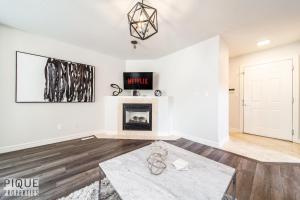 a living room with white walls and a fireplace at LUXURIOUS 6 Bed Home I Fireplace I near Sports Park I with Double Garage & Fast WiFi! in Edmonton