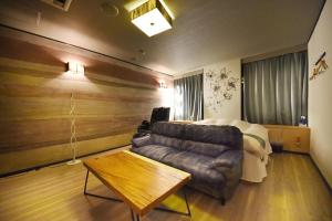 a living room with a couch and a bed at Hotel LALA minato - Adult Only in Nagoya