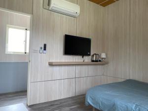 a bedroom with a flat screen tv on a wall at Taichung HSR Homestay in Wuri