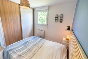 a small bedroom with a bed and a window at L' Évéa Rooftop in Le Relecq-Kerhuon