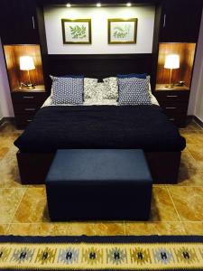 een slaapkamer met een groot bed met een blauwe poef bij The Royal Luxury Superior Queencot in Amman