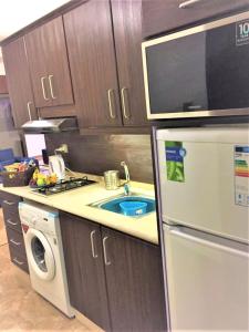 a kitchen with a sink and a stove and a refrigerator at The Royal Luxury Superior Queencot in Amman