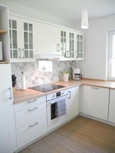a kitchen with white cabinets and a stove top oven at SEASIDE APARTMENTS - MOSSY GREEN in Eckernförde
