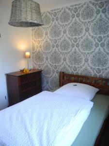 Un dormitorio con una cama y una mesa con una lámpara. en SEASIDE APARTMENTS - MOSSY GREEN, en Eckernförde