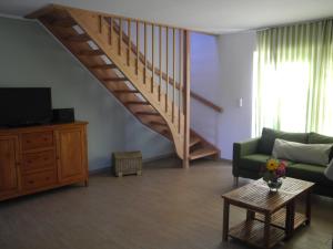 ein Wohnzimmer mit einem Sofa und einer Treppe in der Unterkunft SEASIDE APARTMENTS - MOSSY GREEN in Eckernförde