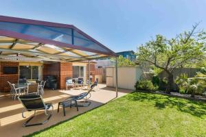 a backyard with a patio with chairs and a table at Avenue Family Retreat in Rosebud