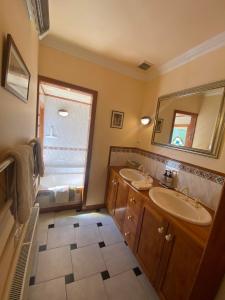 a bathroom with two sinks and a large mirror at Twin Totara Cottage in Upper Hutt