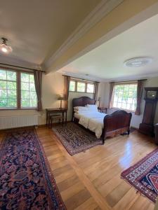 a bedroom with a bed and two rugs at Twin Totara Cottage in Upper Hutt