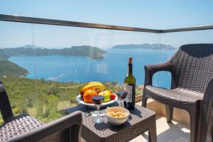 a table with a bowl of fruit and a bottle of wine at Golden Rose Suit pension in Kaş