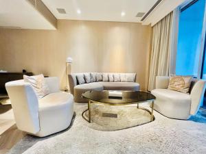 a living room with two chairs and a coffee table at FIVE Palm Jumeirah Resort - 2 Bedrooms plus Maids and Private Jacuzzi - ModernLux in Dubai