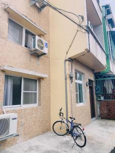 屏東市的住宿－四季小空間，停在大楼旁边的一辆蓝色自行车