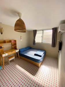 屏東市的住宿－四季小空間，一间卧室配有一张床和一张书桌