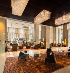 een lobby met stoelen en tafels in een gebouw bij Eastin Grand Hotel Sathorn in Bangkok