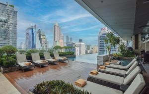 a balcony with couches and a view of a city at Eastin Grand Hotel Sathorn in Bangkok
