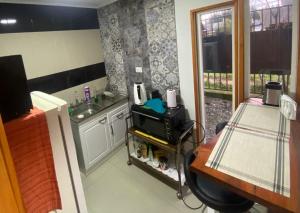 Habitación con cocina con fregadero y mesa. en Hostal Ejecutivo, en Victoria