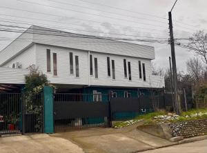 a white house with a fence in front of it at Hostal Ejecutivo in Victoria