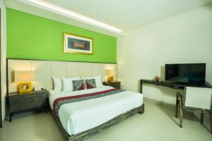 a bedroom with a large bed and a flat screen tv at Royal Samaja Villas in Seminyak