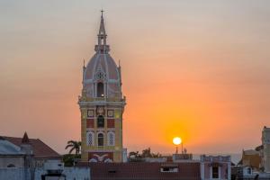 einen Uhrturm mit Sonnenuntergang im Hintergrund in der Unterkunft Voilá Centro Histórico in Cartagena de Indias