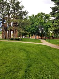 a park with green grass and trees and a path at Town House Motor Inn in Worland