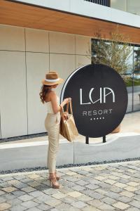 a woman wearing a hat standing in front of a store at LUA Resort - Adults only in Balatonfüred