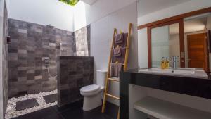 ein Bad mit einem WC und einem Waschbecken in der Unterkunft Lempuyang Boutique Hotel in Karangasem
