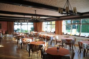 a dining room with tables and chairs and windows at Gasthof-Pension Ortner in Stadl an der Mur