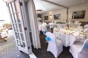 a banquet room with white tables and white chairs at Lion Hotel in Worksop