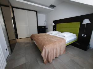 um quarto com uma cama grande e uma cabeceira verde em Klass 302 em Kranjska Gora