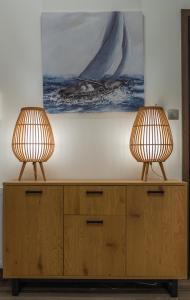 two lamps sitting on top of a wooden cabinet at Max Blue apartment, a stay like no other in Piraeus