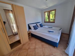 a bedroom with a bed with blue pillows and a window at Apartments Casia in Baška