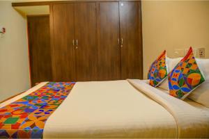 a bedroom with a large bed with a wooden cabinet at FabHotel Hibiscus Stays in Chennai