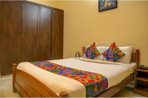 a bedroom with a bed with a wooden cabinet at FabHotel Hibiscus Stays in Chennai