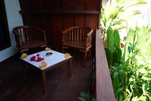 two chairs and a table on a porch at Gili Mesari Cottages & Homestay in Gili Trawangan