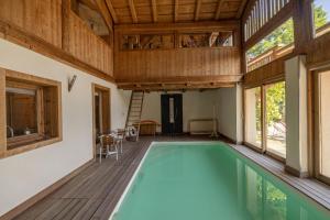 einen Innenpool in einem Haus mit Holzdecke in der Unterkunft Ferme de Faustine 2 - piscine in Saint-Gervais-les-Bains