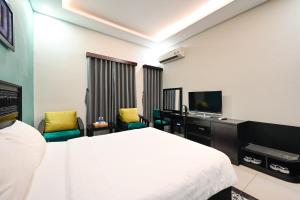 a hotel room with a bed and a flat screen tv at Ohana Hotel - Near Bitexco in Ho Chi Minh City
