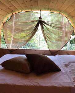 a bed with a large window in a tent at Campeggio il Bosco in Entracque