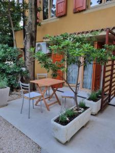 a wooden table and chairs and a tree in front of a building at Apartments Casia in Baška