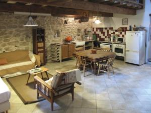 cocina y sala de estar con mesa y nevera en Maison d'Hôtes Lou Cliou, en Cliousclat