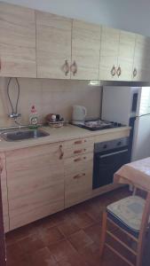 a kitchen with wooden cabinets and a sink and a stove at House Branka in Kampor +7 photos