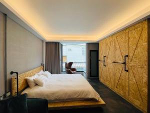 1 dormitorio con 1 cama y puerta de madera grande en 阡陌-頂加民宿 en Tainan