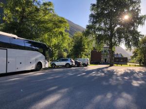 un autobús estacionado al lado de una calle con coches en Rjukan Gjestehus, en Rjukan