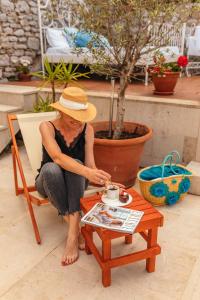 a woman sitting on a chair next to a coffee table at Boutique Hotel Capitano in Herceg-Novi