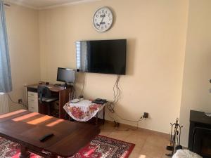 uma sala de estar com uma mesa e um relógio na parede em Ubytování v apartmánu, 2 ložnice, na farmě em Bžany