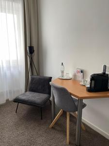 a desk with two chairs and a table with a phone at MAX Hotel Düsseldorf in Düsseldorf