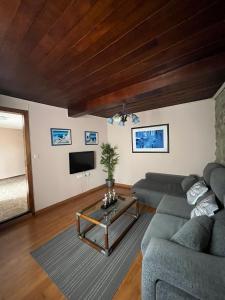 ApartamentosArturo CasaRural Pancarale-Llanes في يانس: غرفة معيشة مع أريكة وطاولة
