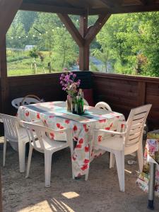 uma mesa e cadeiras com uma mesa e flores sobre ela em Ubytování v apartmánu, 2 ložnice, na farmě em Bžany