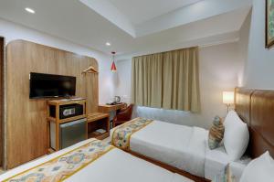 Un pat sau paturi într-o cameră la The Beacon Hotel Vadodara