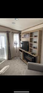 a living room with a flat screen tv and a lamp at Meadows 3 NEW BEACH HOLIDAY PARK in Dymchurch