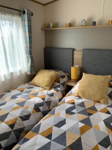 two beds sitting next to each other in a bedroom at Meadows 3 NEW BEACH HOLIDAY PARK in Dymchurch